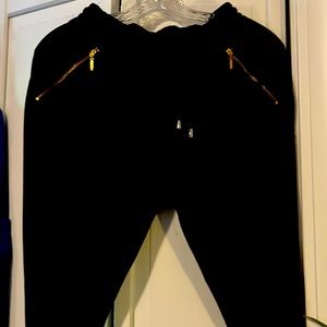 Black slim joggers with gold zipper pockets